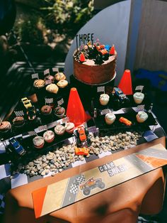 a table topped with lots of cupcakes and cakes