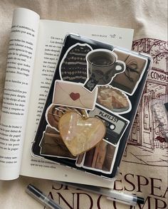 an open book sitting on top of a table next to a cup of coffee and pen