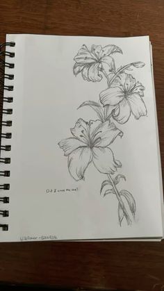 a drawing of some flowers on a wooden table next to a pen and ink marker