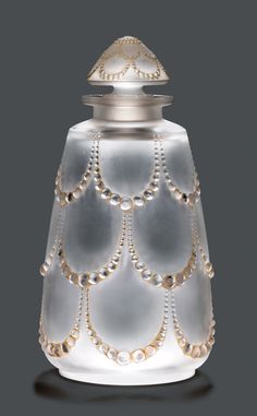 a white glass vase with pearls on it