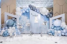 an entrance decorated with blue and white balloons for a winter wonderland themed birthday or baby shower