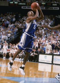 a basketball player is jumping up to dunk the ball in front of an audience