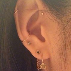 a close up of a person's ear with two piercings on top of it