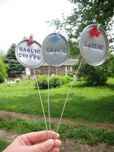 a person holding up some fake garden markers