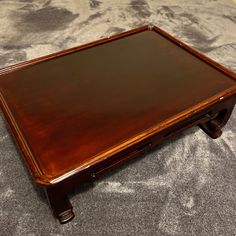 a small wooden table with drawers on top