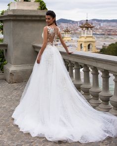 a woman in a wedding dress standing on a balcony