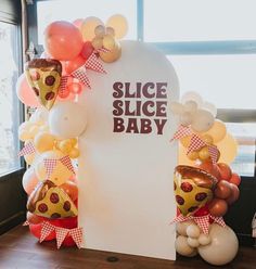 a sign that says slice slice baby with balloons around it and some other items on the table