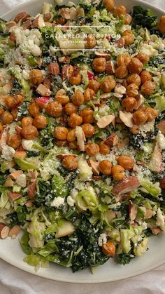 a white plate topped with salad covered in nuts