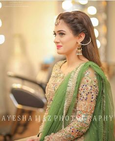 a woman in a green sari is posing for the camera