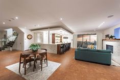 a living room filled with furniture and a fire place next to a dining room table