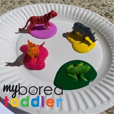 four plastic toy animals on a paper plate with the words my bored todder over it