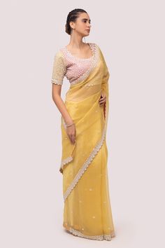 Mustard saree in organza base with sequins, stone and cutdhana embroidery. Paired with embroidered blouse.
Component: 2
Pattern: Embroidered
Type Of Work: Sequin, stone, cutdhana
Neckline: Round
Sleeve Type: Half
Fabric: Organza
Color: Yellow
Other Details: 
Back tassel tie-up
Occasion: Puja - Aza Fashions Yellow Georgette Saree, Yellow Color Saree, Festive Saree, Reception Saree, Reception Lehenga, Designer Saree Blouse, Embroidered Sarees, Embroidered Border, Sequence Work