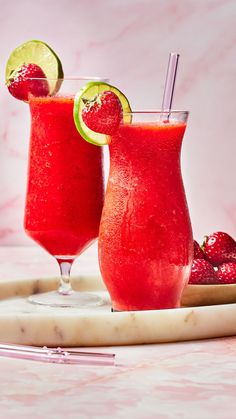 two glasses filled with watermelon and limeade on top of a marble tray