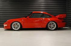 a red sports car parked in front of a garage door