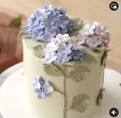 a white cake with blue and purple flowers on it