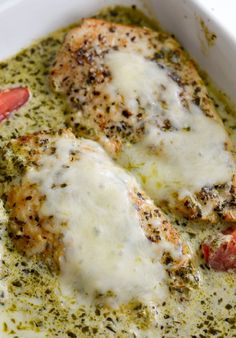 two pieces of chicken covered in cheese and tomatoes on top of broccoli sauce