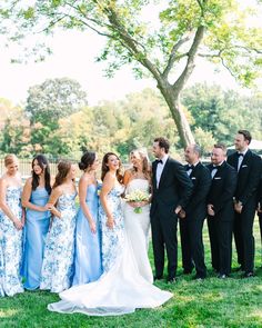 a group of people in formal wear standing next to each other on a grass field