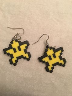 a pair of earrings with yellow and black pixeles