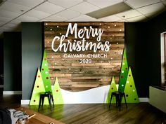 a merry christmas sign on the side of a wall in a room with wooden floors