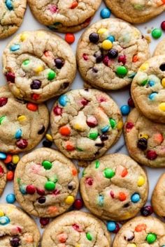 cookies with m & m's and multi - colored candies are arranged on a white surface