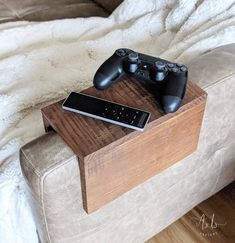 two video game controllers sitting on top of a wooden table