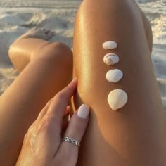 a woman's legs with seashells painted on the back of her leg