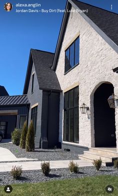 the front of a house with black doors and windows