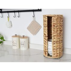 a kitchen counter with a basket and two rolls of toilet paper