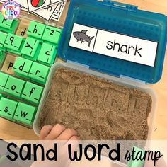 a sand and word stamp set in a plastic container with the words shark on it