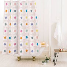 a bathroom with a bathtub, shower curtain and potted plant on the floor