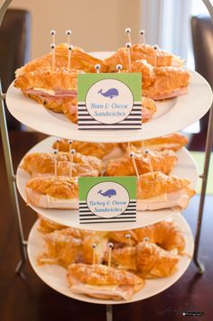 three tiered trays filled with food on top of a wooden table