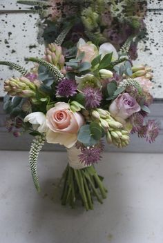 a bouquet of flowers sitting on top of a white counter next to a window sill