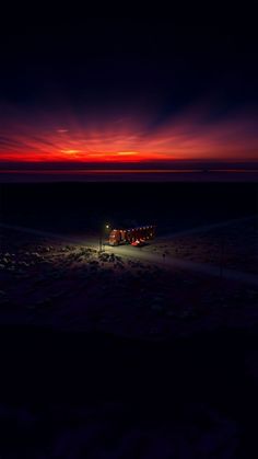 the sun is setting over an empty parking lot in the middle of nowhere, with no cars parked on it