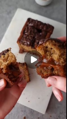 someone is holding up some desserts on top of a white paper towel with chocolate and caramel toppings