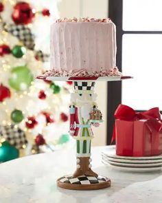 a cake sitting on top of a table next to a christmas tree