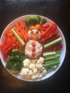 a white plate topped with carrots, broccoli and cauliflower