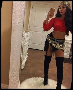 a woman taking a selfie in front of a mirror wearing a belly dance outfit