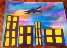 a piece of paper with a painting of a man in the sky above some buildings