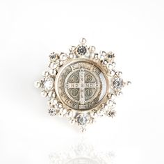 The Cloister San Benito Ring - there for peace, protection, and beauty...Always. Wear It... Sterling silver ring shank 8 Austrian crystals San Benito medallion under resin 42 hand-soldered metal balls Measures 1.75 inches circumference and weighs 27 grams & Believe! Care for with a clean dry cloth (no jewelry cleaner please). We pride ourselves on our customer service. Our secret? We believe in Angels. Handcrafted in San Miguel de Allende, Mexico. Nickel-free Heirloom Jewelry For Anniversary, Heirloom Nickel-free Jewelry For Anniversary, Engraved Spiritual White Gold Jewelry, Engraved White Gold Spiritual Jewelry, Spiritual Engraved White Gold Jewelry, Luxury Silver Commemoration Ring, Luxury Silver Jewelry With Si Clarity, Symbolic Medallion Jewelry For Commemoration, Symbolic Coin-shaped Collectible Jewelry