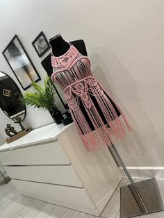 a mannequin dressed in pink and black with fringes on it's head