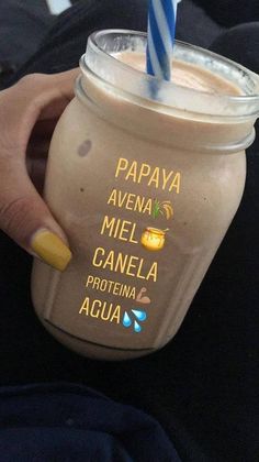 a person holding a drink with a straw in it's cup and the words papaya avena mel canela written on it