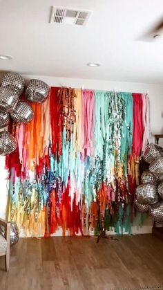 a room filled with lots of disco balls and colorful streamers hanging from the ceiling