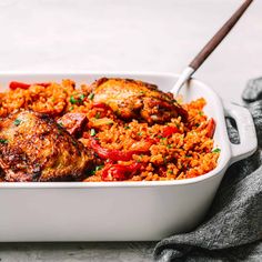 a white casserole dish filled with chicken and rice