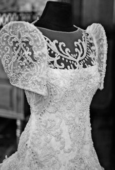 the back of a wedding dress is shown in black and white, with an intricate lace pattern