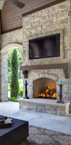 an outdoor fireplace with a flat screen tv above it