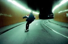 a man riding a skateboard through a tunnel