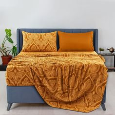 a bed with two pillows on top of it and a blanket draped over the headboard