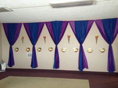 an empty room with purple drapes and clocks on the wall