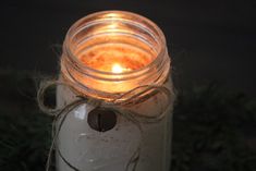 a lit candle in a mason jar with twine around it