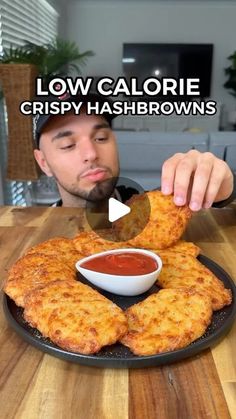 a man is eating some fried food on a black plate with the caption low calorie crispy hashbrowns